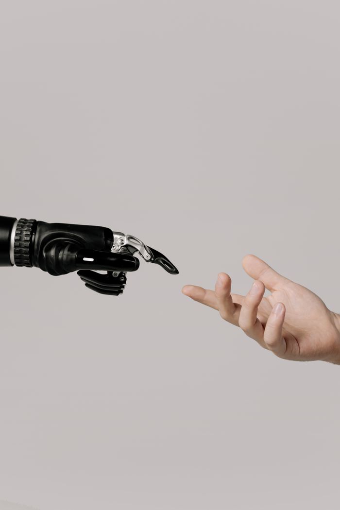 Mastering the First Impression: Your intriguing post title goes here A human hand reaching to touch a bionic prosthetic hand on a white background.