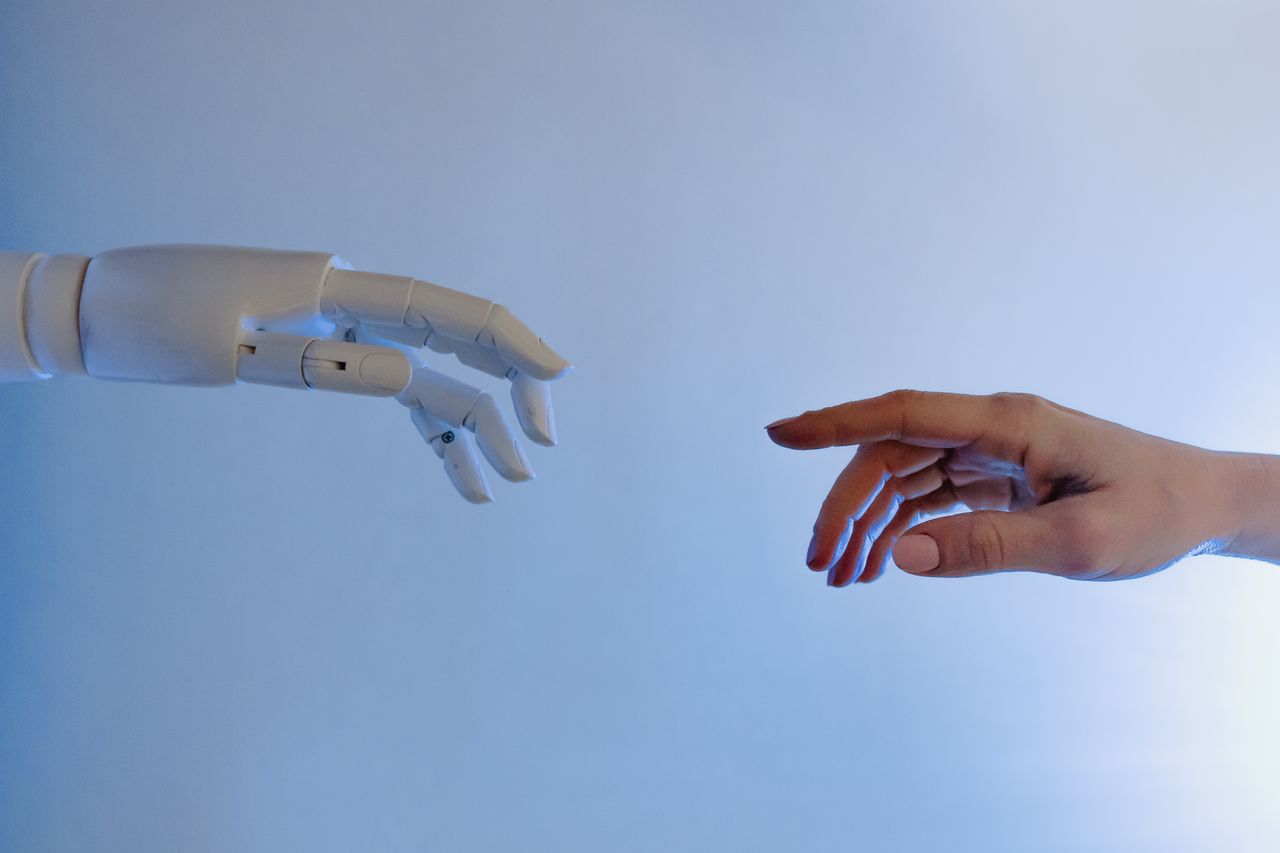 Crafting Captivating Headlines: Your awesome post title goes here A human hand reaching towards a robotic hand symbolizing technology and connection.